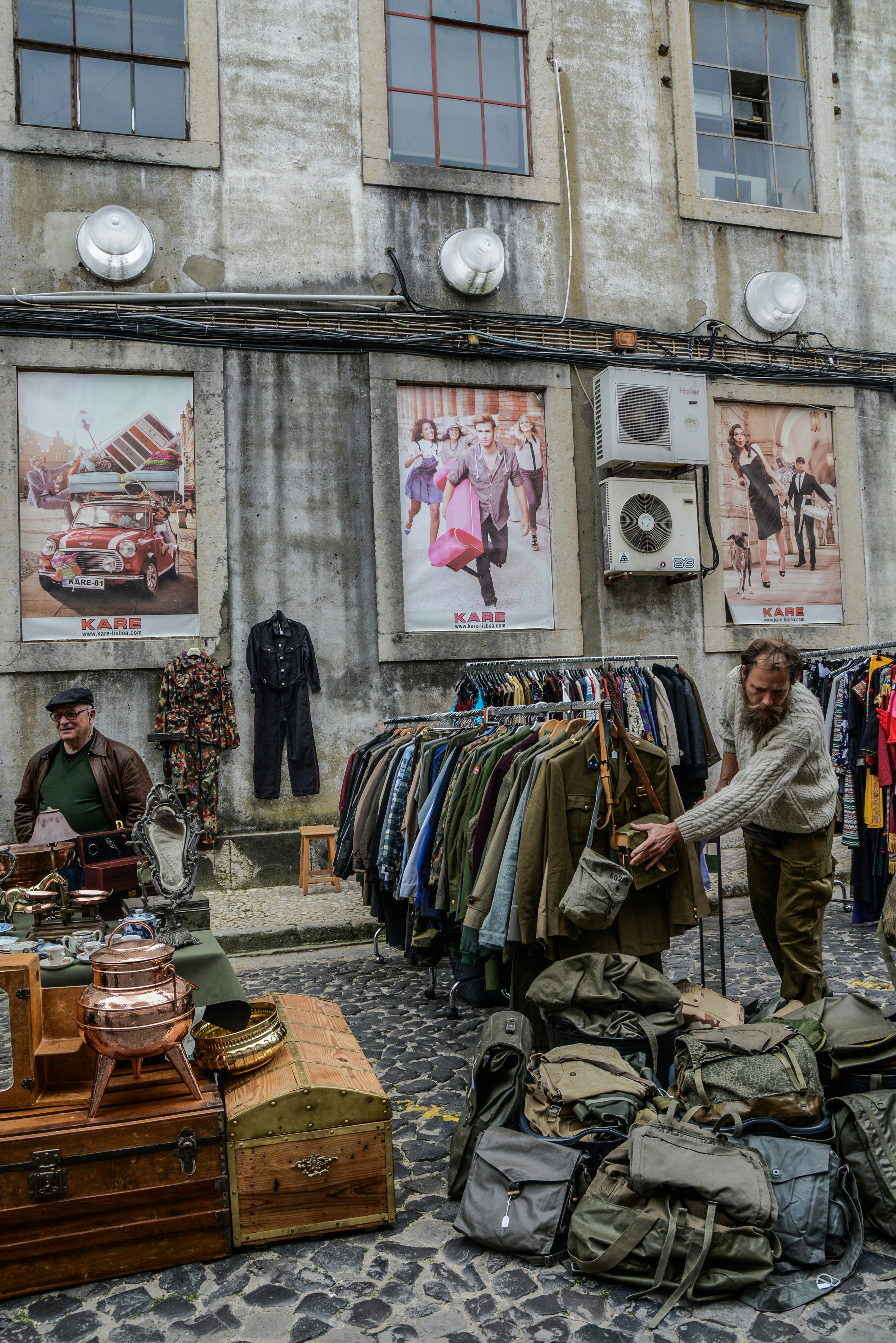 clothes and bags displayed on road near building during daytime